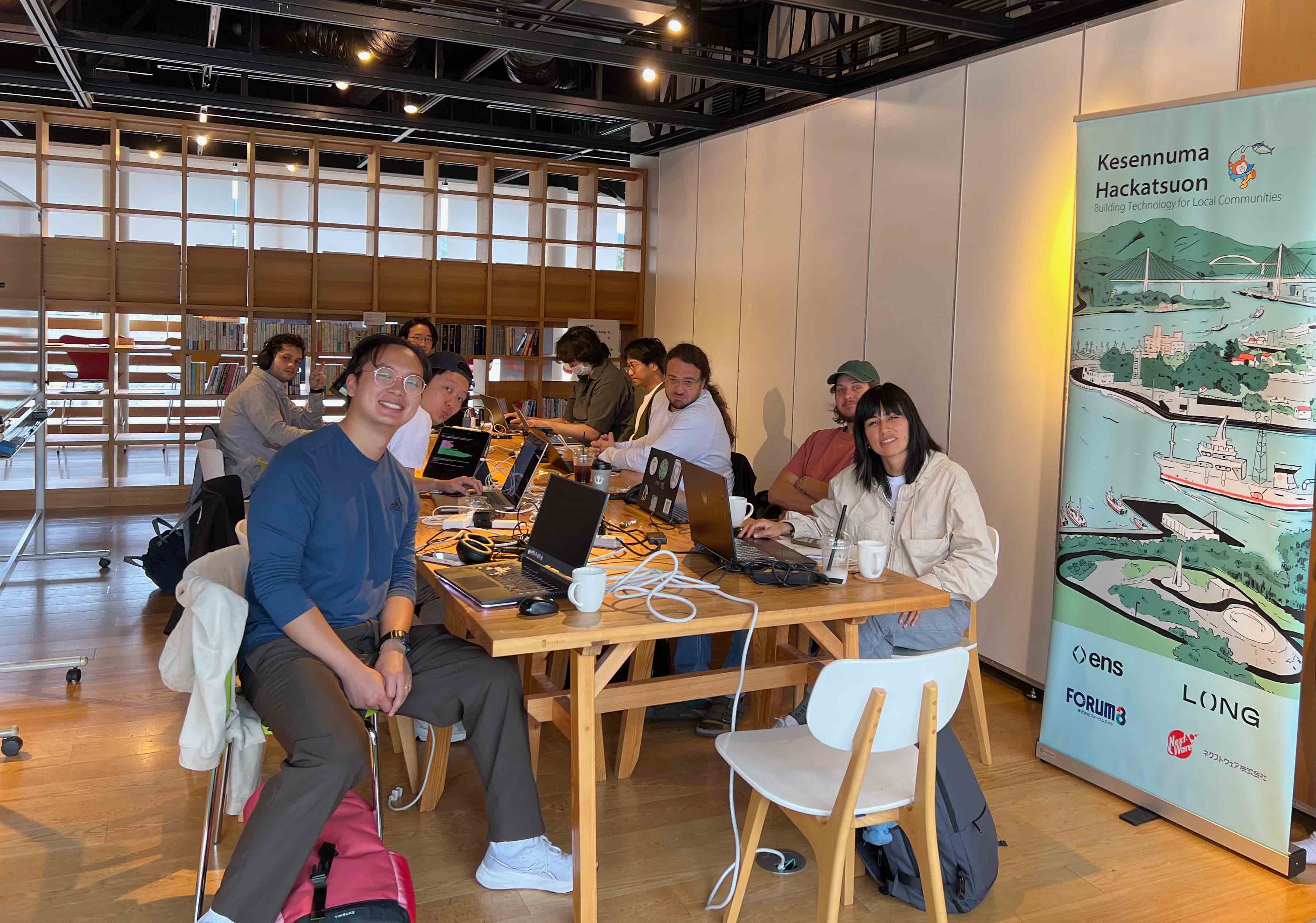 Development team working with Kesennuma Hackatsuon banner
